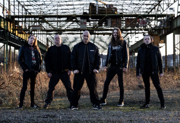 Exumer band promotional photo featuring Mem Von Stein, Ray Mensh, Marc Bräutigam, Alex Voß, and Jerome Reil, German thrash metal, Metal Blade Records, Death Mask Messiah era 2026
